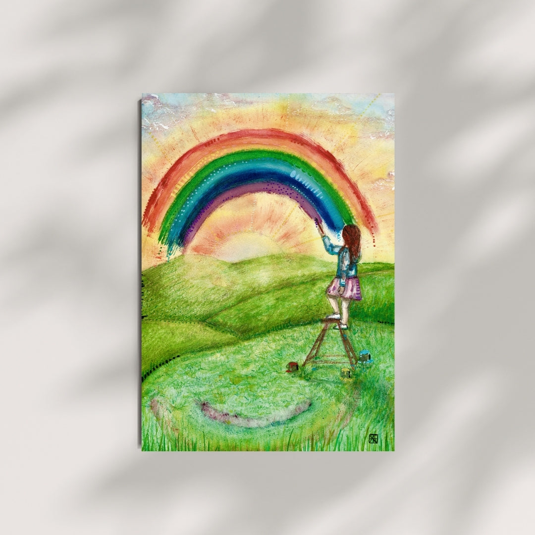 Der farbenfrohe Kunstdruck „Regenbogenfarben“ von Nathalie-Designs zeigt ein Mädchen auf einer Leiter, das einen Regenbogen über eine sonnige Wiese malt. Verträumte Wandkunst und liebevolle Wanddekoration für Wohnzimmer, Kinderzimmer oder Atelier.