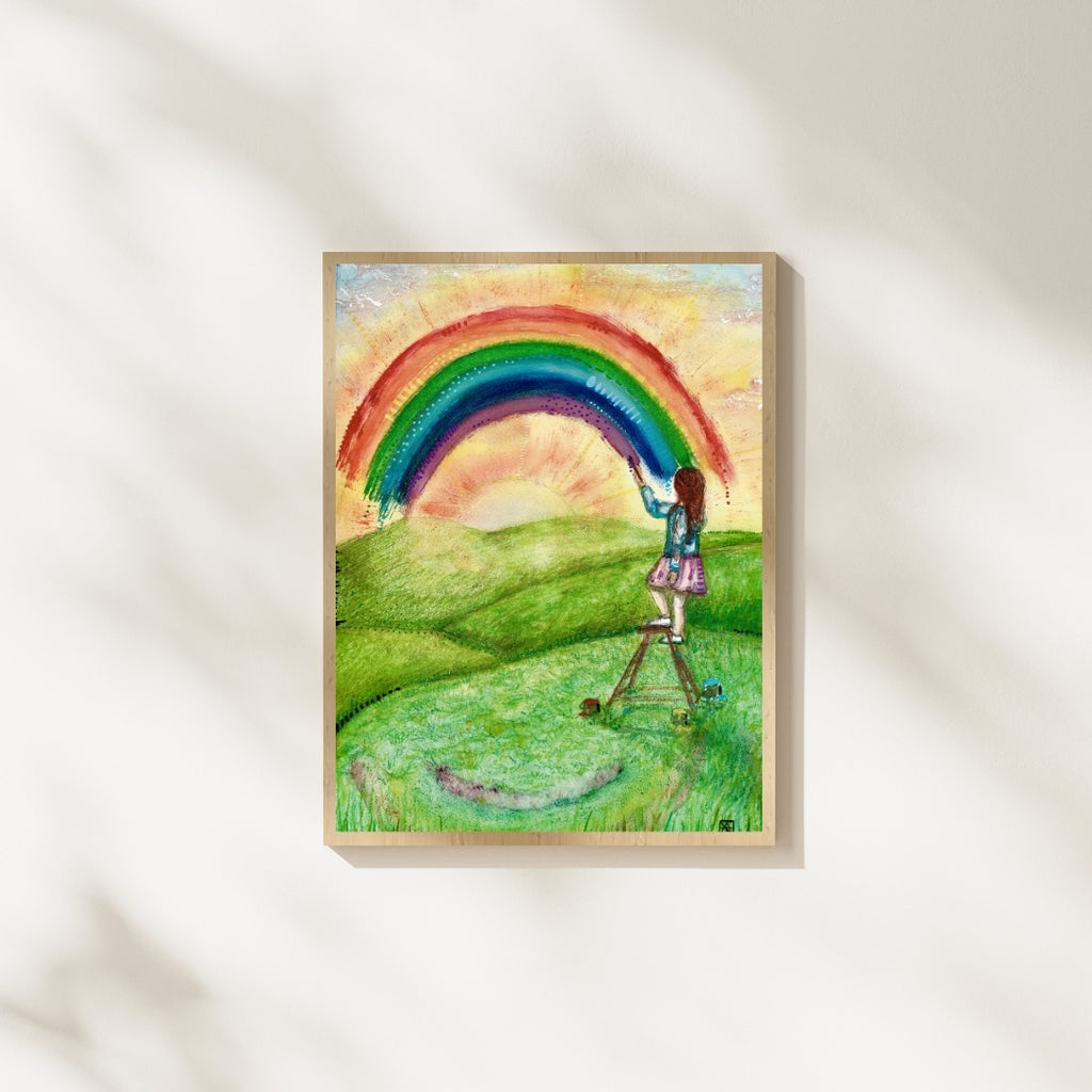 Der farbenfrohe Kunstdruck „Regenbogenfarben“ von Nathalie-Designs zeigt ein Mädchen auf einer Leiter, das einen Regenbogen über eine sonnige Wiese malt. Verträumte Wandkunst und liebevolle Wanddekoration für Wohnzimmer, Kinderzimmer oder Atelier.
