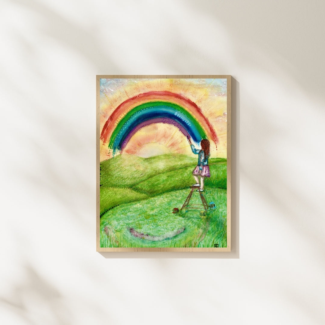 Der farbenfrohe Kunstdruck „Regenbogenfarben“ von Nathalie-Designs zeigt ein Mädchen auf einer Leiter, das einen Regenbogen über eine sonnige Wiese malt. Verträumte Wandkunst und liebevolle Wanddekoration für Wohnzimmer, Kinderzimmer oder Atelier.